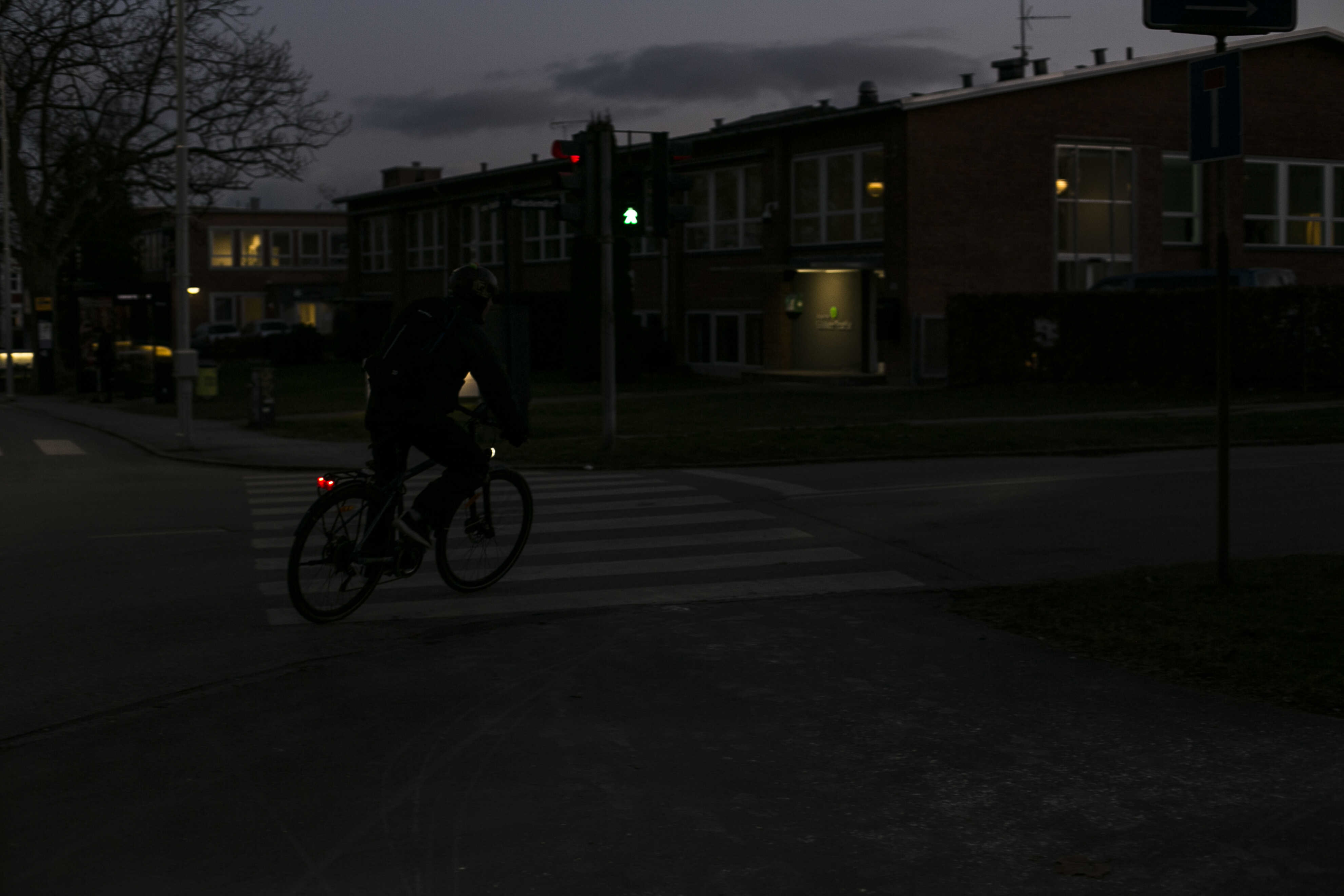 Foto af cykellist i mørke, som viser hvor svær cykelisten er at se med reflekser og lygter.